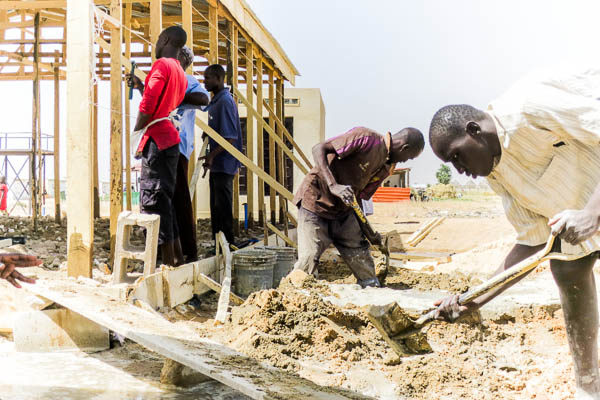 Mixing cement for the floor of the basic maternity at an IDP camp in Maiduguri, Borno State, Nigeria